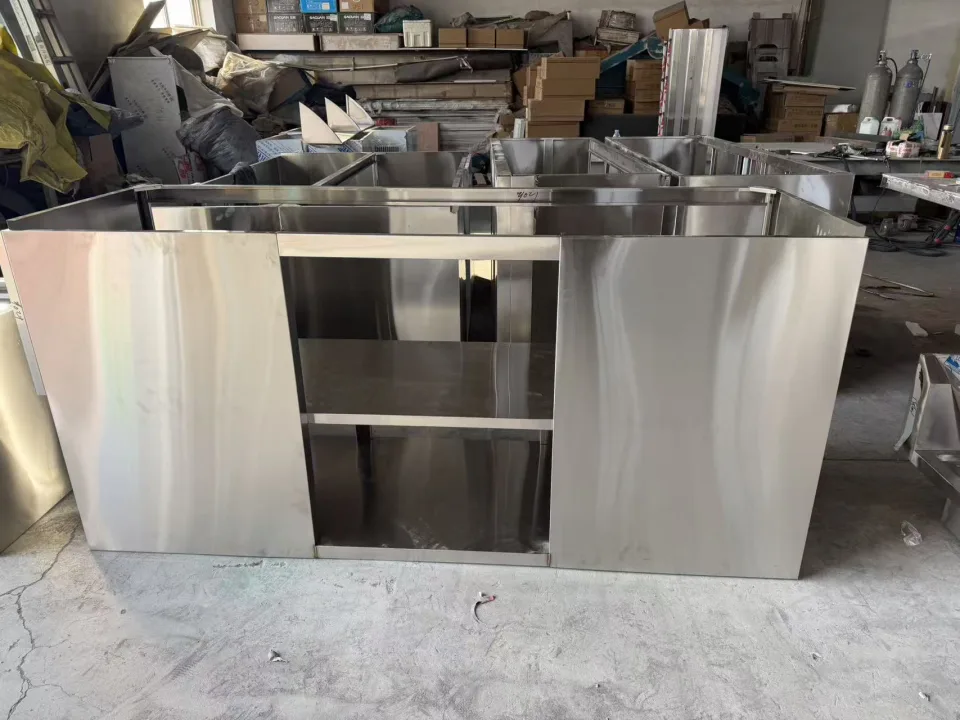 Stainless cabinet body during assembly with protective film and front opening visible