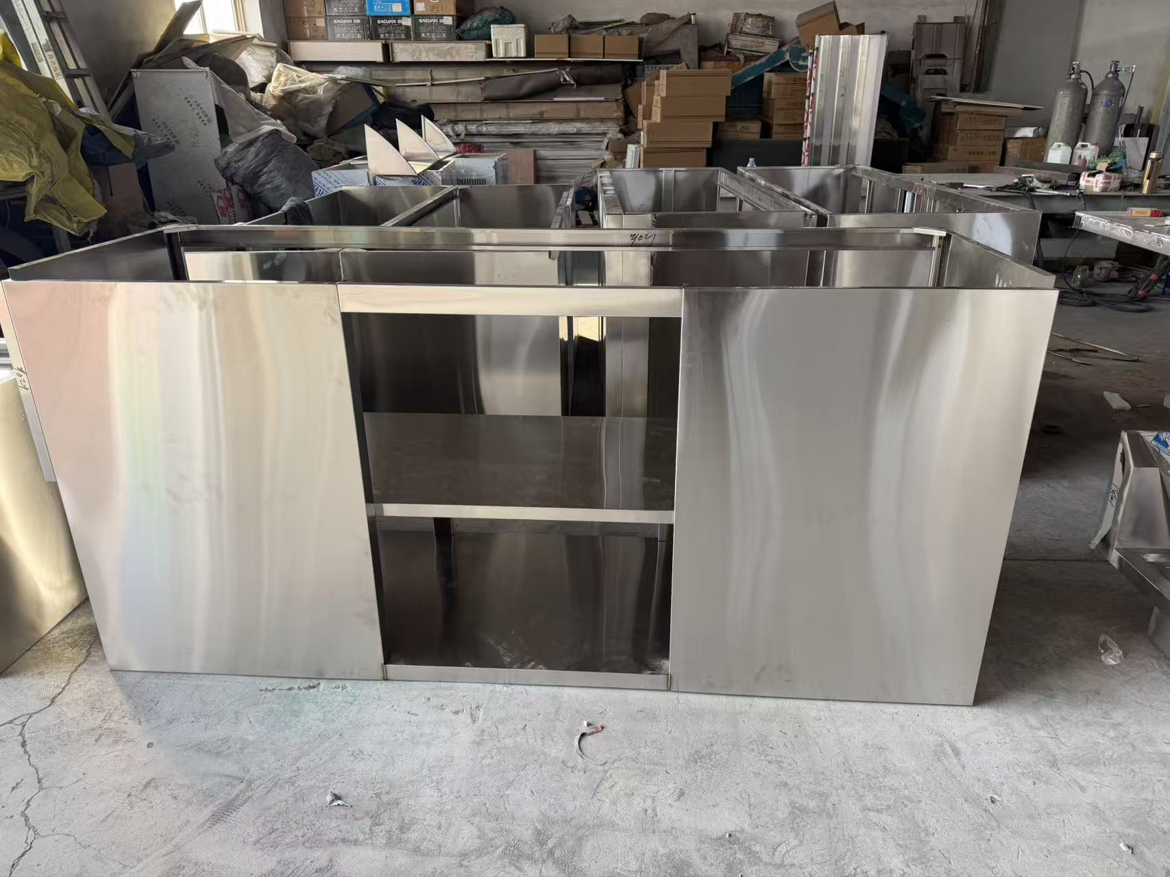 Unfinished stainless steel cabinet body photographed during assembly in a manufacturing partner workshop