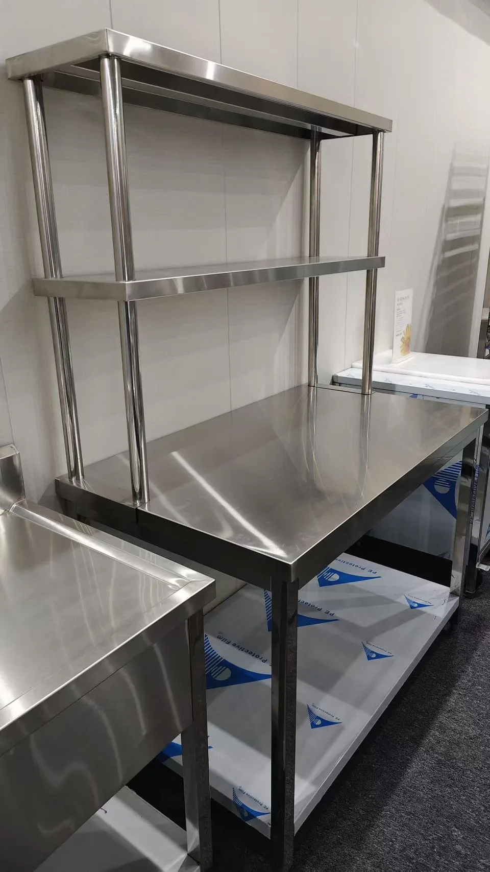 Stainless worktable with upper shelves photographed at the manufacturing partner