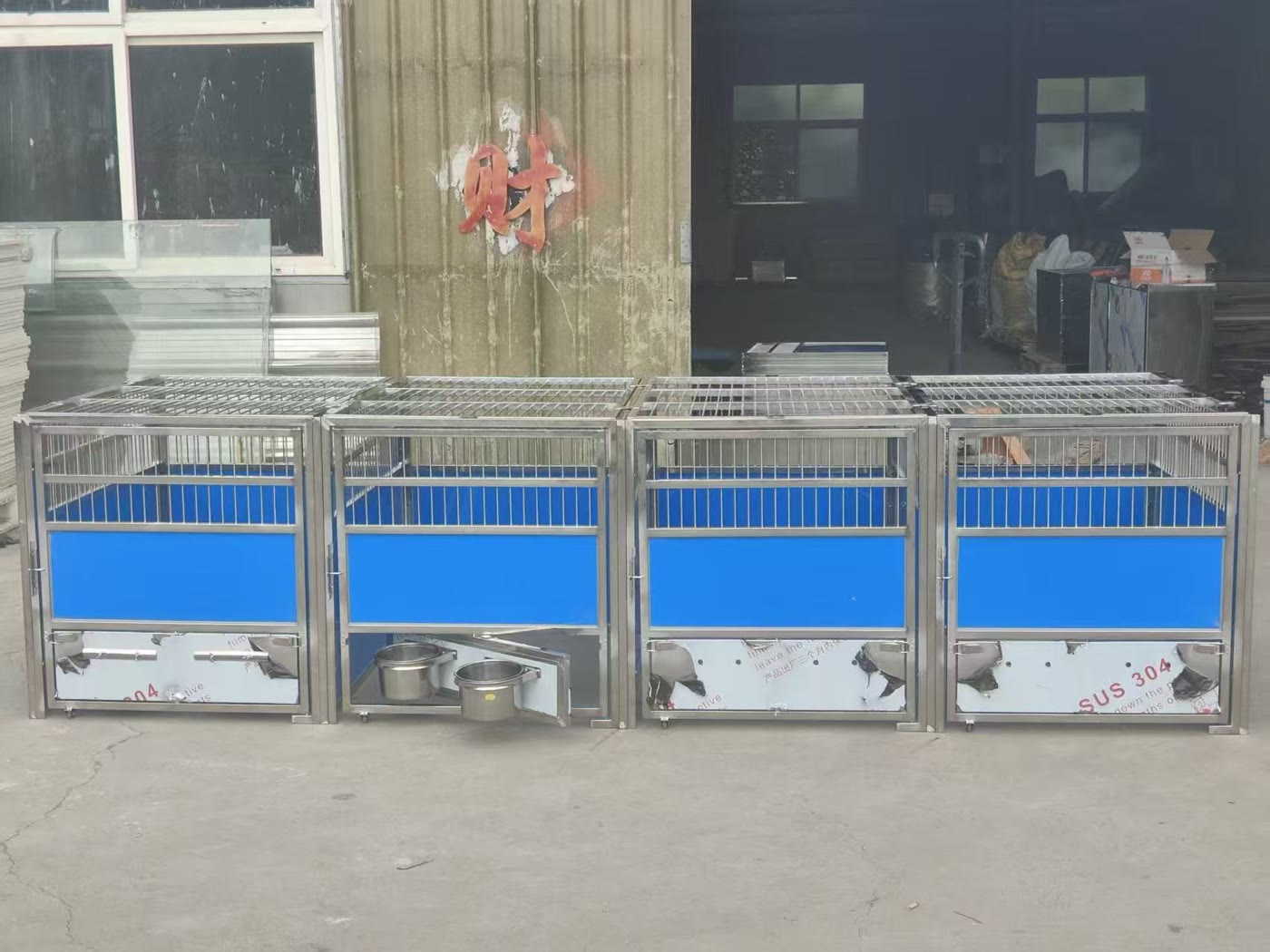Four custom stainless steel dog kennel modules with removable bowl holders